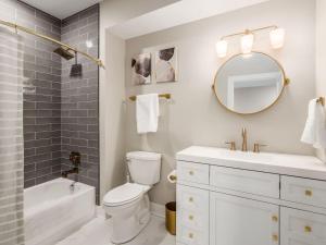 a bathroom with a toilet and a sink and a mirror at High End New Build, Rooftop Hot Tub, City Views in Milo +34 photos