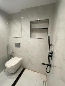 ein weißes Bad mit einem WC und einem Fenster in der Unterkunft VESTA - Luxury APT - 3BR - Gardenia Residence in Kairo