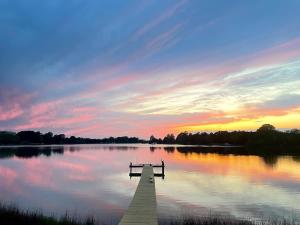 HacksneckSpacious 3BR with Dock on Working Farm with Pool Table的日落时分湖中的一个码头