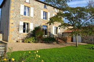 a brick house with a lawn in front of it at "La Maison de Villars" au coeur de la nature in Pressac