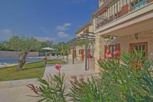 - un bâtiment avec une cour agrémentée d'une piscine et de fleurs dans l'établissement Villa Marija in Pekici (Haus für 8-10 Personen), à Svetvinčenat