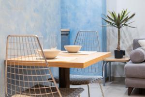 a dining room with a wooden table and two chairs at Evis Cosmos 2 Center - Meno Homes 11 in Xanthi