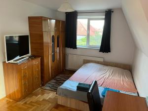 a small bedroom with a bed and a television at Rent a room Bruno in Făgăraş