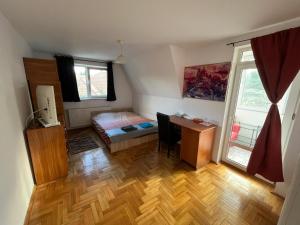 a bedroom with a desk and a bed and a window at Rent a room Bruno in Făgăraş