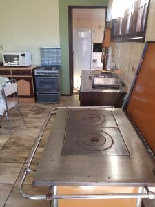 Una cocina con una estufa en el medio. en Casa Completa, 300m da Praça, Wi-Fi, 130m quadrados, 4 Camas de Casal, 4 Quartos, Até 11 Pessoas, Quintal com Vasta Área Verde, Varanda nos Fundos, Garagem Coberta 1 Carro, Estacionamento Interno 2 Carros, Churrasqueira, Fogão a Lenha, en Cambará