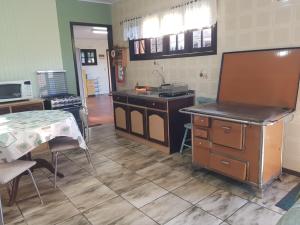 a kitchen with a table and a sink and a counter at CASA COMPLETA CENTRAL, 4 Qtos, Wi-Fi, 130m quadrados, 4 Camas Casal, Churrasqueira Interna, Quintal com Área Verde e Pomar, Varanda, 2 Banheiros, 9 Pessoas, Área Frontal, Garagem Coberta, Estacion Interno 2 Carros, Fogão a Lenha in Cambará