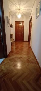 a hallway with a hard wood floor and a door at Habitación en A Coruña con baño privado in Visma