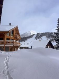 a ski lodge with snow on the ground at Chalet les 3 Montagnards - 200m des pistes in Montgenèvre