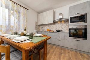 eine Küche mit Holztisch und ein Esszimmer in der Unterkunft Lorenzo in Klanice (Haus 2 für 6 Personen) in Dobrinj + 32 Fotos