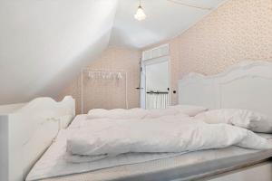 una camera da letto bianca con un grande letto con lenzuola bianche di 20621-Brundby-Trekanten-12 a Brundby