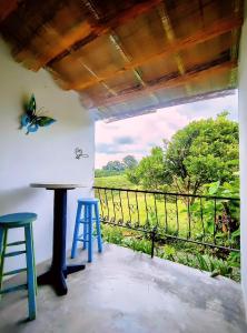 uma varanda com uma mesa e bancos e uma borboleta na parede em Betania Alojamiento Rural Quindío Eje Cafetero espectacular! em Circasia mais 26 fotografias