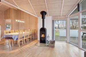 un camino in una sala da pranzo con tavolo e sedie di TV1683-Strandby-Bygmarken-2 a Bratten Strand