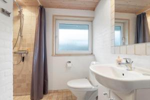 un bagno con lavandino, water e finestra di TV1683-Strandby-Bygmarken-2 a Bratten Strand Altre 14 foto