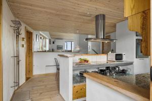 een keuken met houten plafonds en een aanrecht bij JB363-Fjerritslev-Tolderstien-8 in Torup Strand