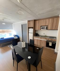 a kitchen and living room with a table and chairs at Edificio Barcelona in Temuco