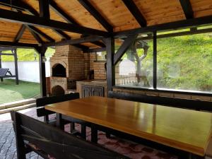 a dining room with a wooden table and a fireplace at Casa din Codru in Şimon