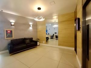 een woonkamer met een zwarte bank en een hal bij SUH Copacabana 43 New Confort in Rio de Janeiro