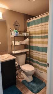 a bathroom with a toilet and a sink and a shower at Oasis at Heritage in Fort McMurray