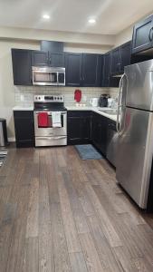 a kitchen with black cabinets and stainless steel appliances at Oasis at Heritage in Fort McMurray +13 photos