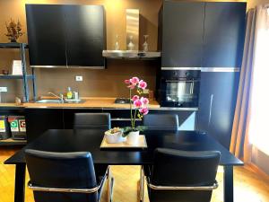 a kitchen with a black table and black cabinets at Appartamento Cremona Stazione in Cremona