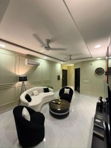 un salon avec un canapé, des chaises et une table dans l'établissement Zameen Opel, à Lahore
