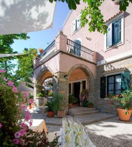 a house with a balcony and flowers in front of it at Villa Andor in Ankaran