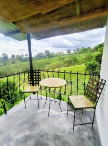 a table and chairs on a balcony with a view at Betania Alojamiento Rural Quindío Eje Cafetero espectacular! in Circasia