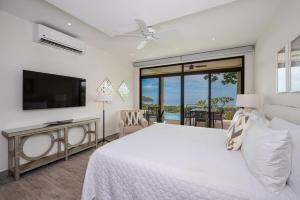 Un dormitorio con una cama blanca y un televisor. en Casa Bella Sunset-pool Villa In Coco Tasteful, en Coco 51 fotos más