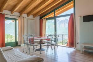 a dining room with a table and chairs and a balcony at Fenil Del Santo in Tremosine Sul Garda