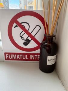a no trumpet infiltration sign and a vase with sticks in it at Замечательная новая квартира на Ботанике in Chişinău
