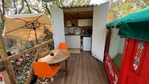 a wooden deck with a table and an umbrella at Yourte Shangrila - La Roque sur Pernes in La Roque-sur-Pernes +22 photos