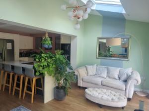 a living room with a couch and a kitchen at Fab 2 double bed detached house in Peterborough
