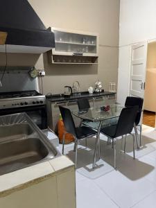 a kitchen with a table and chairs and a stove at House of Peace in Fombeni