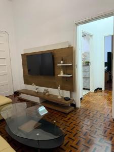 a living room with a tv and a glass table at House of Peace in Fombeni