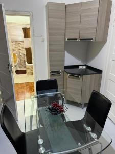 a glass table with two chairs and a kitchen at House of Peace in Fombeni