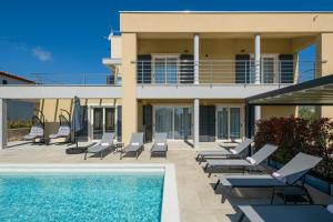 a villa with a swimming pool and lounge chairs at Villa Valentina in Krnica - Haus für 8-9 Personen in Krnica