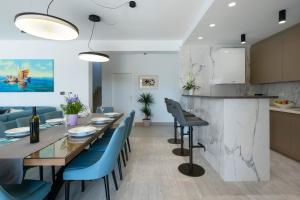 a kitchen and dining room with a table and blue chairs at Villa Valentina in Krnica - Haus für 8-9 Personen in Krnica