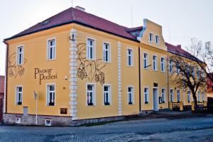 ein gelbes Gebäude an der Straßenseite in der Unterkunft Penzion Pivovar Podlesí in Příbram