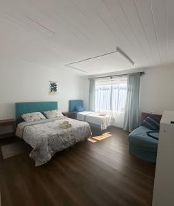 a bedroom with two beds and a window at Habitación 2 a 3 pers. in Temuco