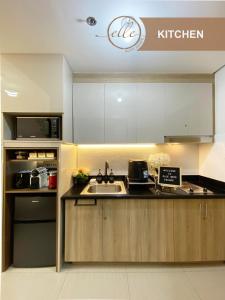 a kitchen with a sink and a microwave at Modern Unit at Shore 2 Mall of Asia by Elle Suite in Manila