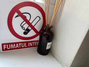 a vase with bamboo sticks in it next to a sign at Комфортная квартира на Ботанике in Chişinău