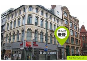 a large building with a sign that says you are here at Satori Serviced Apartments in Manchester