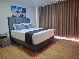 a bedroom with a large bed and a large window at Hotel Rosa Mistika Inn in Arequipa