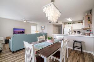 a dining room and kitchen with a table and chairs at Fenimore Mill 1A Mermaid's Song in Cedar Key +4 photos