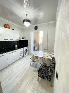 a kitchen with a table and a dining room at Чистая квартира для добрых людей in Bosteri