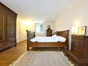 a bedroom with a bed and a dresser and a rug at Homeby, Casale Bera in Cossano Belbo