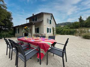 a table with chairs and a red table cloth at Homeby, Casale Bera in Cossano Belbo
