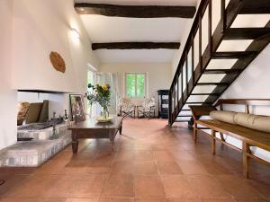 a large living room with a staircase and a table at Homeby, Casale Bera in Cossano Belbo
