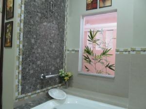 a bathroom with a sink and a window and a tub at Venezia Suites Resort Panglao in Panglao Island