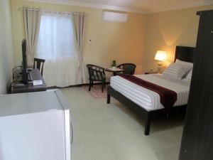 a bedroom with a bed and a television in it at Venezia Suites Resort Panglao in Panglao Island
